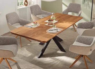 Holztisch mit sechs Polsterstühlen auf Teppich, gedeckt mit Geschirr und Karaffe